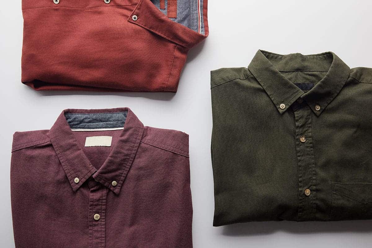colorful-shirts Three folded shirts in various colors, showcasing New Braunfels custom shirts.